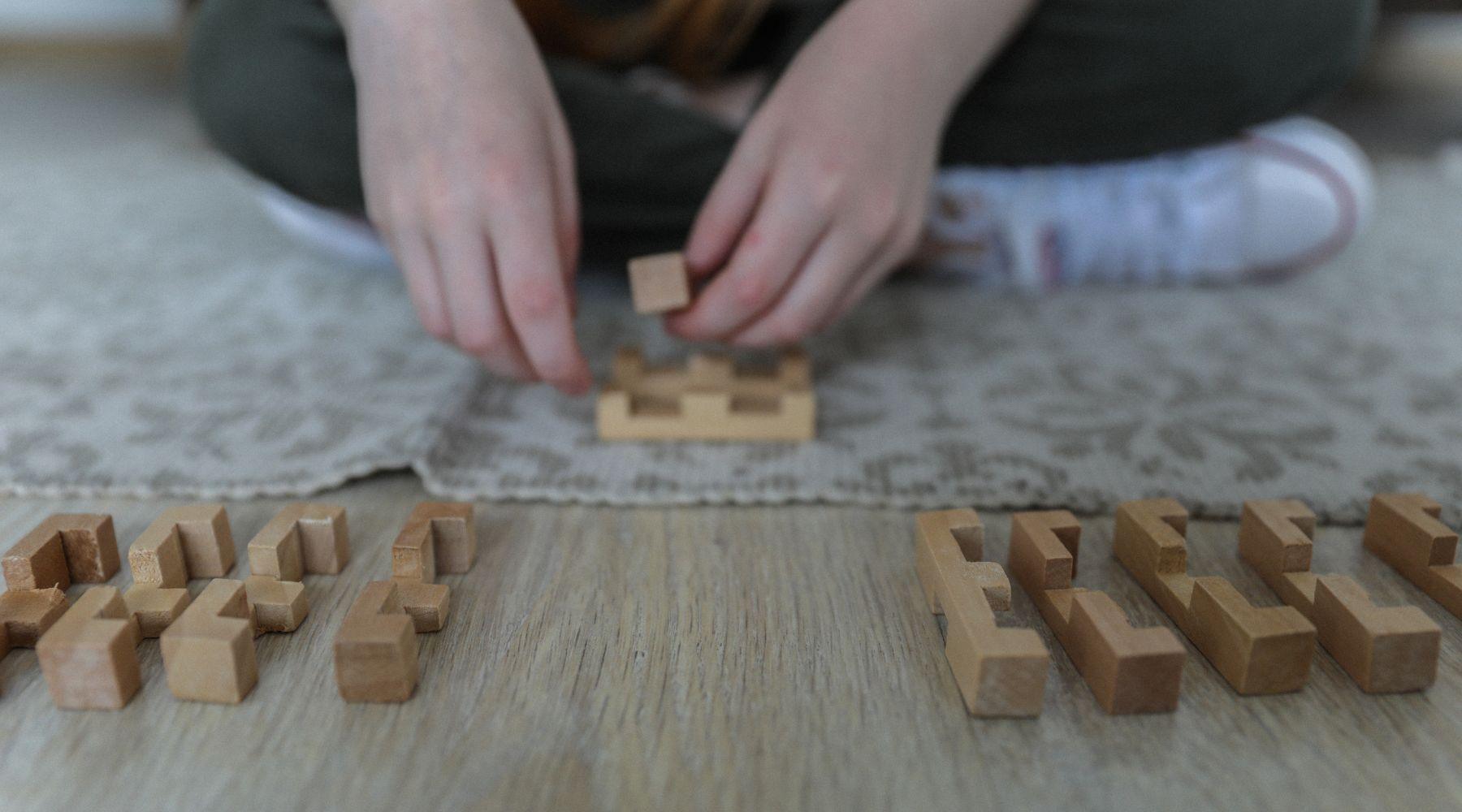 child playing with wooden brain teaser puzzle toy